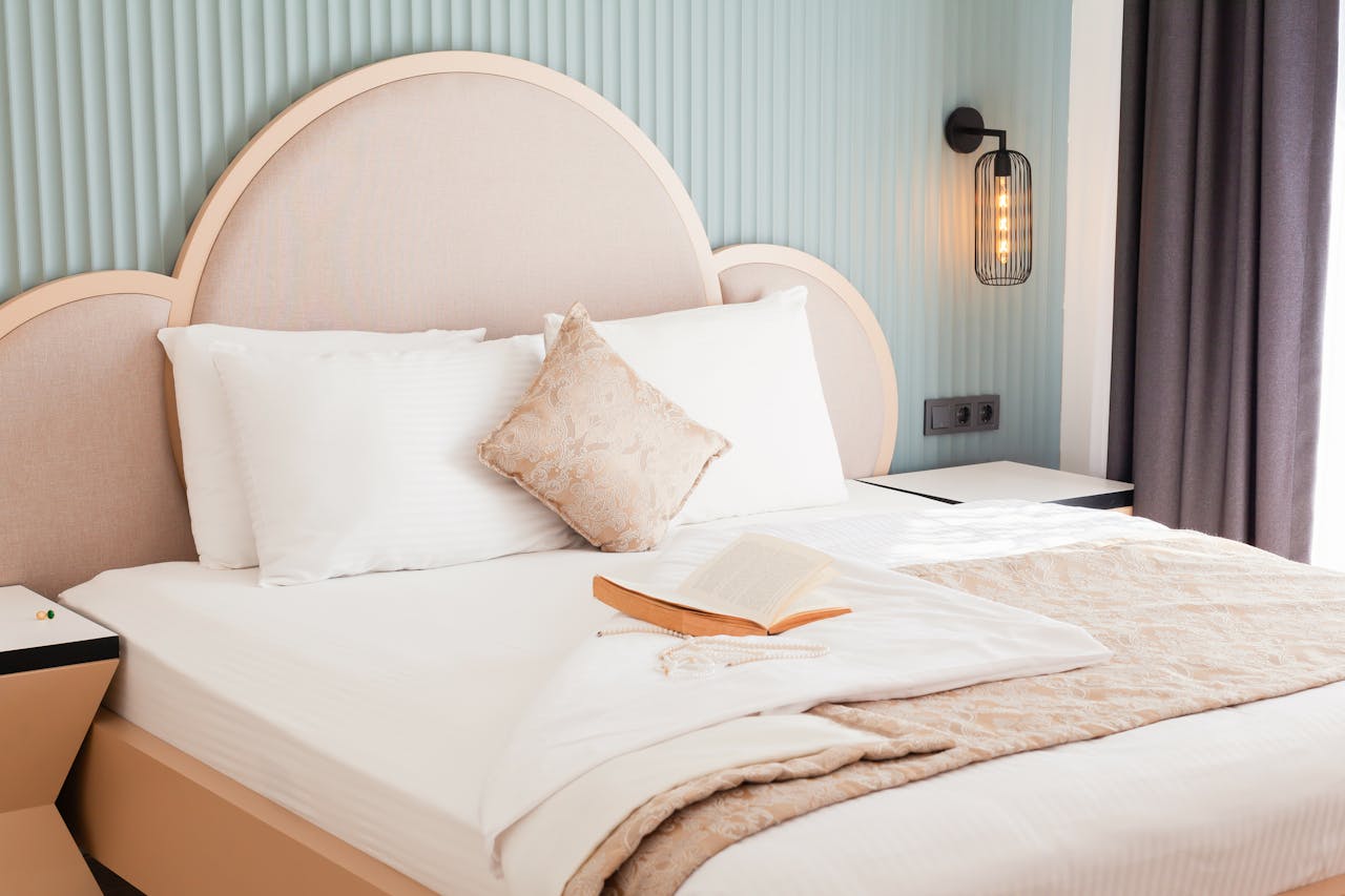 A luxurious hotel bedroom featuring elegant bedding and an open book, exuding comfort and style.